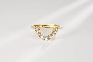 Macro view of a gold-plated V-shaped ring featuring sparkling white cubic zirconia stones