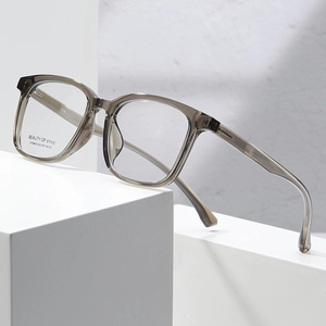 Stylish square frame glasses in translucent tea gray on minimalist stone display