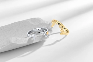 Detailed view of silver and gold dachshund rings with Love You Forever engraving