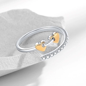 Adjustable two-tone silver ring featuring double gold heart charms and cubic zirconia accents