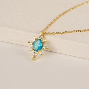 Collana stella polare dorata con zircone blu e diamanti bianchi su una catena a croce