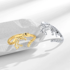 Gothic dinosaur skeleton open rings in gold and silver finish on white stone base