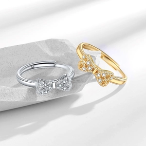 Micro-paved zircon bow rings in gold and silver finish with beaded edge detailing