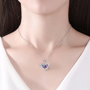 Cupid's arrow heart necklace with blue and purple stones on female model's neck