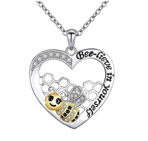 Detailed close-up of honeycomb heart pendant with Bee-lieve in yourself engraving