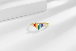 Macro shot of gold adjustable ring featuring a colorful pixelated rainbow heart design