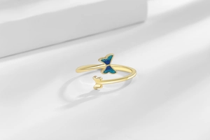 Details des Schmetterlingsrings mit blauen Emaille-Flügeln und goldenem Ringband
