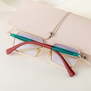 Close-up of golden rectangular sunglasses with green temples and beige leather pouch