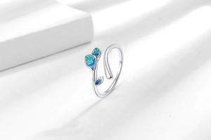 Detail of silver leaf ring featuring blue-green enamel inlay and adjustable open band