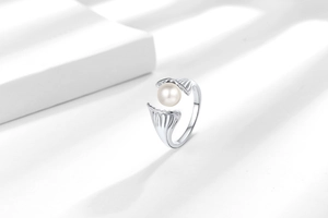 Detail showing the seashell pearl ring design with ribbed silver texture and shadows