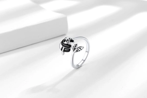 Detailed close-up of a panda and bamboo leaf design on a polished silver open ring