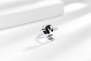 Detail of panda shaped open ring showing fine black enamel and silver leaf accents