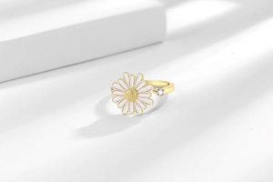 Macro shot of rotatable daisy ring with gold plating and white zircon stone detail