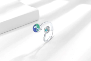 Detail of hamsa hand and tai chi enamel ring with sparkling zircon inlays on white blocks