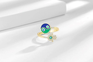 Detail of 18K gold-plated open ring with colorful enamel Tai Chi and Hamsa Hand motifs