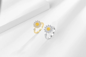 Detailed close-up of gold and silver sunflower spinner rings with zircon on white steps