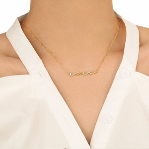 Collier doré ondulé élégant avec cristaux brillants porté sur un mannequin femme
