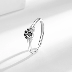 Adjustable silver ring with black cat paw pattern and angel wings in minimalist style