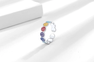 Close-up of adjustable flower smiley face ring with colorful enamel inlay on white background