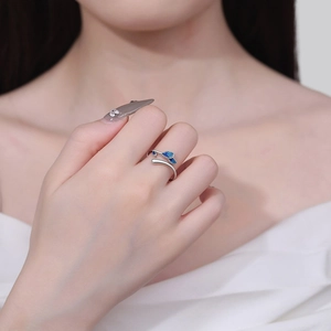Silver open ring with blue leaf design worn on index finger for a minimalist elegant look