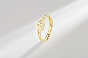 Close-up of golden Celtic Trinity Knot adjustable ring with a polished metallic finish