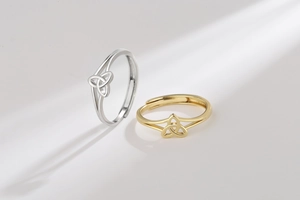 Detailed view of silver and gold triquetra knot rings with adjustable open band