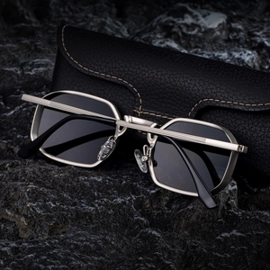 Detail of silver square sunglasses with black lenses on textured leather case