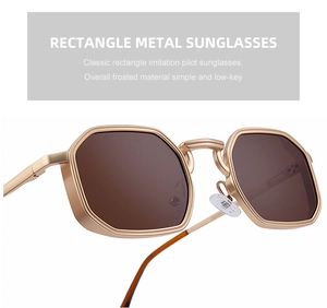 Close-up of retro rectangle metal sunglasses with gold frosted frame and brown lenses