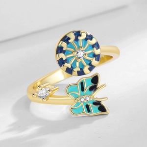 Adjustable gold ring with rotating blue enamel butterfly and circular nautic wheel motif