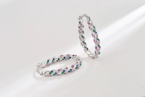 Macro view of silver twist hoop earrings with multicolor pavé set cubic zirconia stones