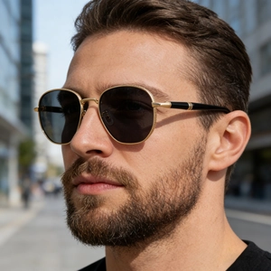 Close-up of golden metal frame with textured engraving on vintage square sunglasses