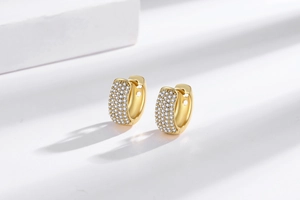 Detail of gold huggie hoop earrings with micro-paved clear cubic zirconia crystals