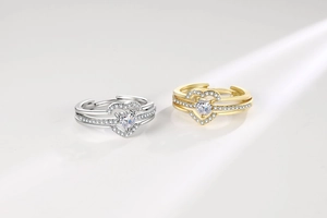 Close-up of adjustable double-band heart rings with sparkling crystals in gold and silver