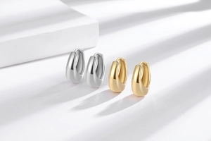 U-shaped teardrop metal earrings in polished gold and silver finish with snap closures