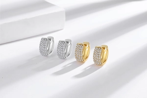 Detail of silver and gold plated huggie hoop earrings with micro-pave zircon crystals