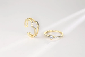 Detail of gold layered rings with heart-shaped zircon and sparkling pavé setting