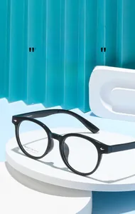 Detail view of round black eyeglass frames with silver metallic studs on a white display pedestal