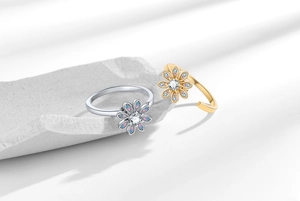 Detail of adjustable rotating daisy rings with pink and blue zircons on stone base