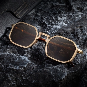 Fashionable square metal sunglasses for men with dark lenses on volcanic rock