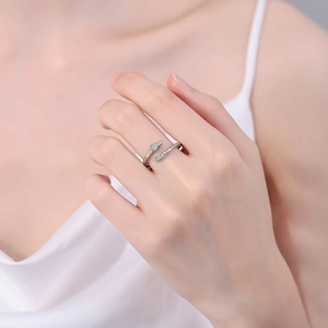 Silver snake wrap ring with sparkling white cubic zirconia and green gem eyes on finger