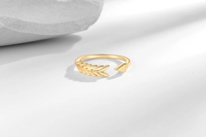 Detail of gold arrow ring featuring textured wheat ear design and high-polished finish