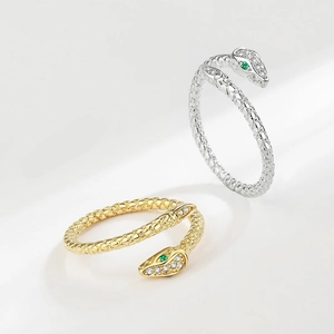 Elegant snake-shaped wrap ring with sparkling crystals and green gem eyes in gold and silver