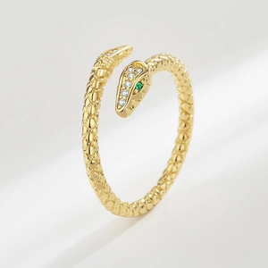 Golden snake-shaped open ring with sparkling crystal pave head and green gemstone eyes