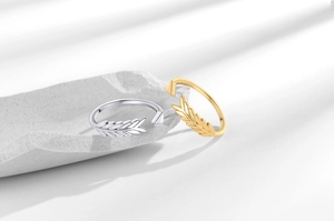Detail of adjustable arrow and feather rings in gold and silver on stone tray