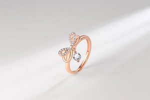 Close-up of rose gold bow ring with sparkling pavé crystals and hanging zircon stone