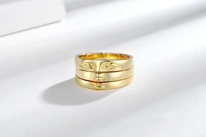 Detailed view of 3-piece gold plated stackable rings forming an abstract human face design