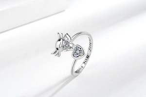 Macro detail of silver ring with axolotl holding heart and Love you forever engraving