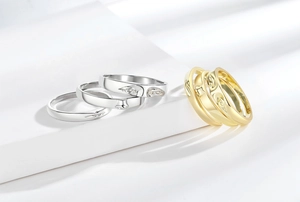 Macro detail of gold and silver ring set featuring eye engravings and zircon inlays