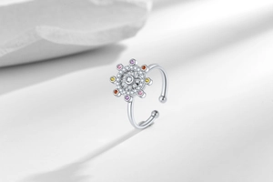 Close-up of spinning ring with colorful gems and sparkling zircon stones on silver band