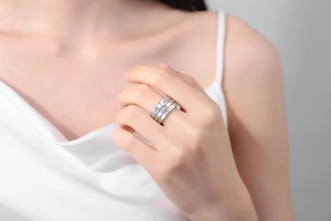 Close-up of three-piece silver-toned stacked rings with engraved eye motifs on model